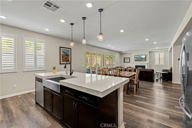 kitchen with dark wood-style flooring, open floor plan, visible vents, appliances with stainless steel finishes, and a sink