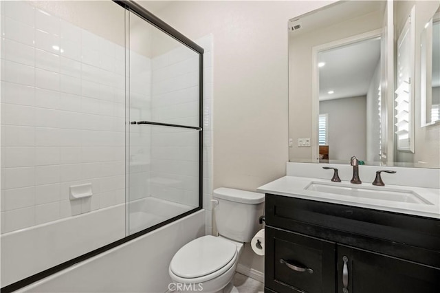 bathroom with toilet, vanity, and bath / shower combo with glass door