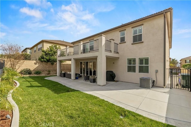 back of property featuring a lawn, a fenced backyard, a patio, stucco siding, and a balcony