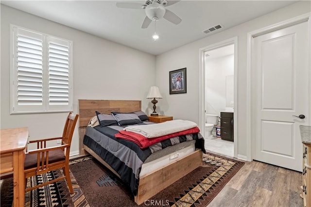 bedroom featuring visible vents, baseboards, ceiling fan, connected bathroom, and wood finished floors