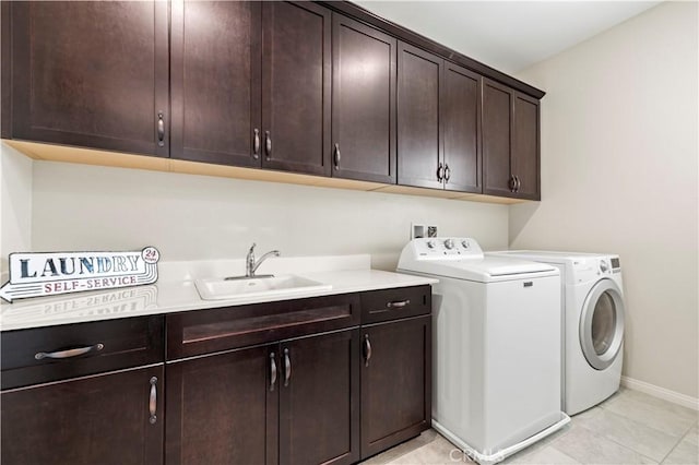 laundry room with baseboards, washing machine and clothes dryer, a sink, and cabinet space