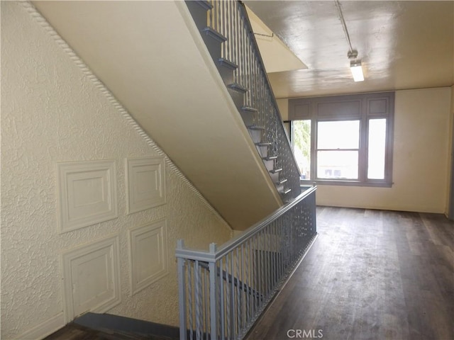 5510 Lexington Ave, Los Angeles, CA 90038 - stairway with track lighting, a textured wall, and wood finished floors