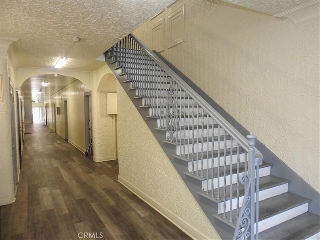 5510 Lexington Ave, Los Angeles, CA 90038 - staircase featuring a textured ceiling, baseboards, wood finished floors, arched walkways, and a textured wall