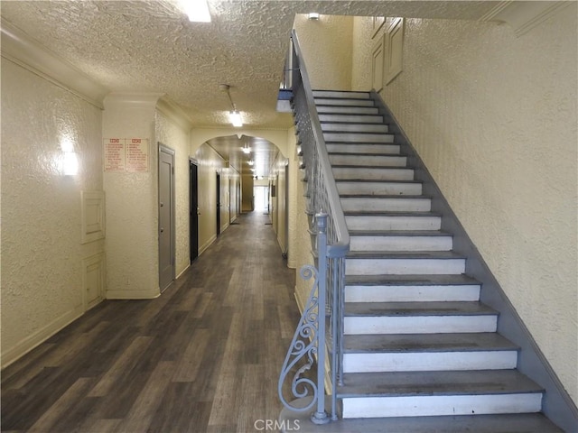 5510 Lexington Ave, Los Angeles, CA 90038 - stairway with a textured wall, wood finished floors, a textured ceiling, arched walkways, and ornamental molding