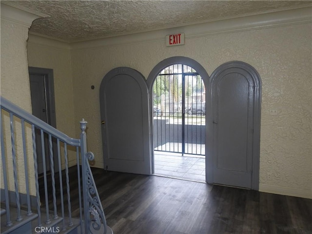 5510 Lexington Ave, Los Angeles, CA 90038 - foyer entrance featuring stairway, a textured wall, a textured ceiling, arched walkways, and wood finished floors