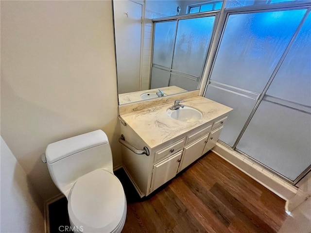 bathroom featuring toilet, a shower stall, vanity, and wood finished floors