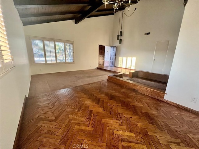 spare room with high vaulted ceiling, beamed ceiling, and an inviting chandelier