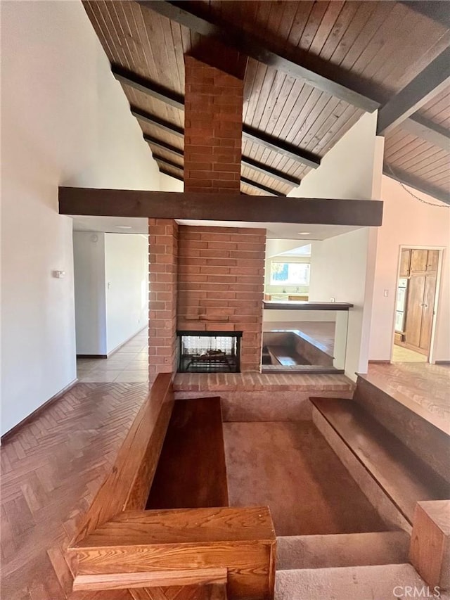 unfurnished living room with beamed ceiling, baseboards, high vaulted ceiling, and a brick fireplace