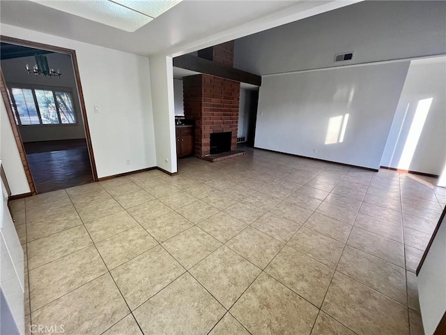 unfurnished living room with light tile patterned floors, a fireplace, visible vents, a chandelier, and baseboards