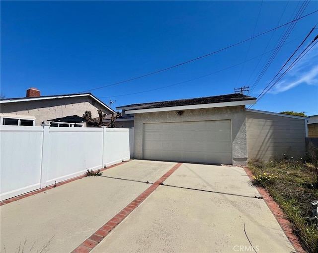 garage with driveway and fence