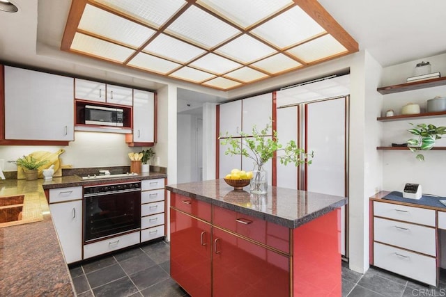 230 W Laurel St Unit 506, San Diego, CA 92101 - kitchen with oven, stainless steel microwave, dark countertops, open shelves, and a kitchen island