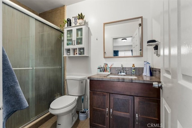 full bath featuring toilet, a stall shower, and vanity
