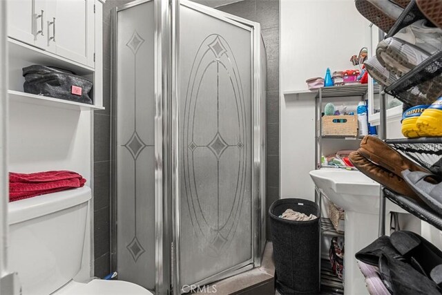 bathroom featuring toilet and a stall shower