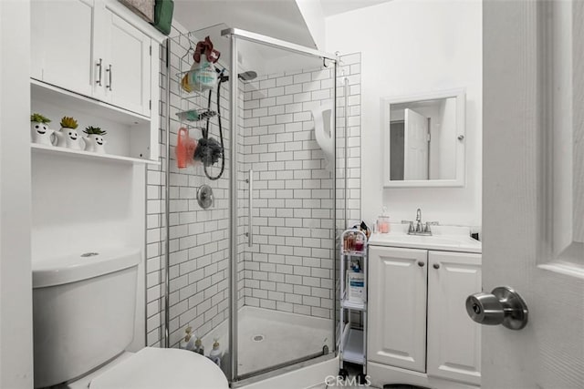 bathroom with a shower stall, vanity, and toilet