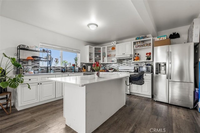 kitchen with open shelves, dark wood finished floors, under cabinet range hood, stainless steel appliances, and decorative backsplash