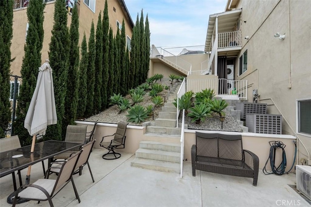 view of patio featuring outdoor dining area and stairs