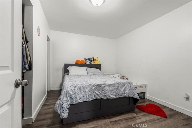 bedroom with baseboards and wood finished floors