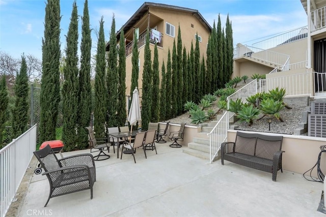 view of patio featuring outdoor dining space and stairway