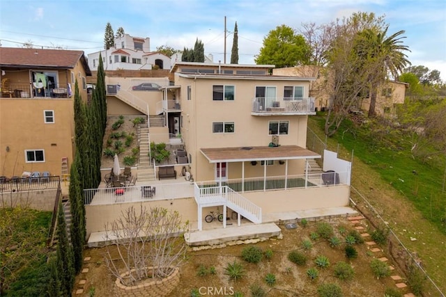 back of house featuring a fenced backyard, stucco siding, a patio, and stairs