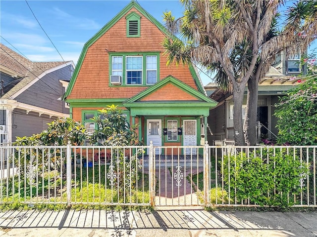 view of front facade with a gambrel roof and a fenced front yard