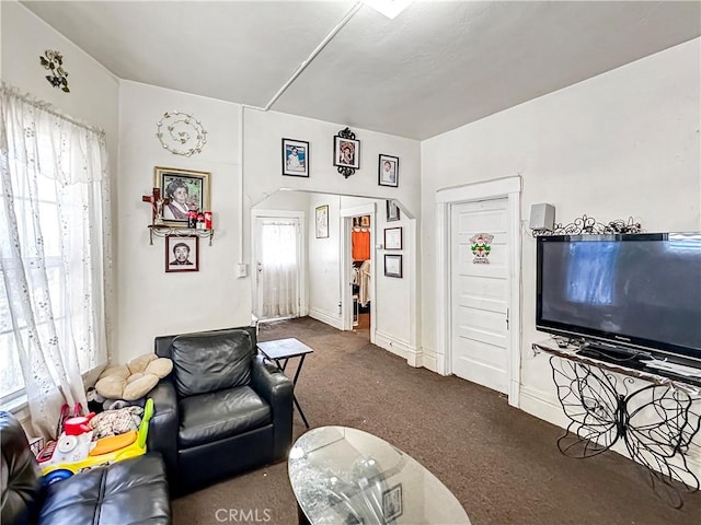 carpeted living area featuring baseboards