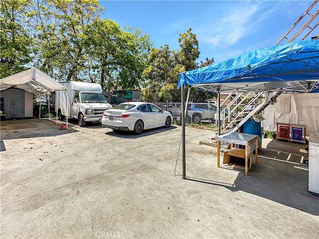view of parking / parking lot featuring a storage unit and fence