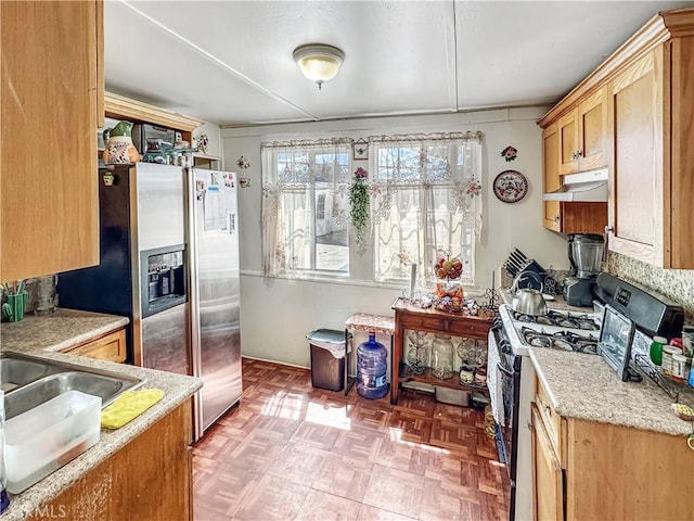 kitchen with under cabinet range hood and appliances with stainless steel finishes