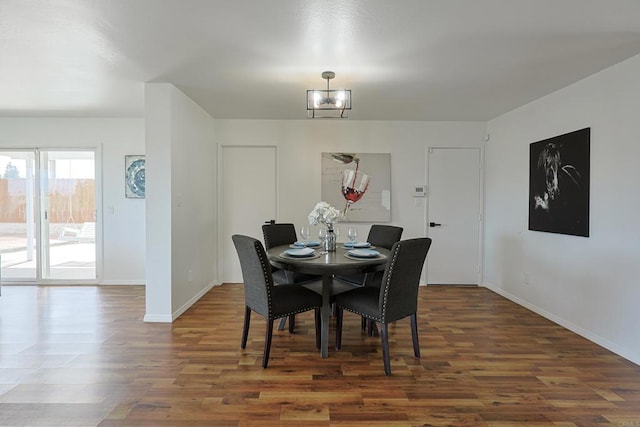 dining room with wood finished floors, baseboards, and a notable chandelier