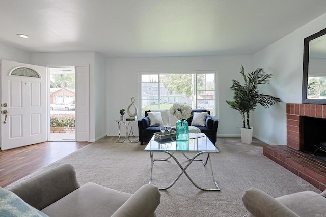 living room with plenty of natural light, a brick fireplace, and baseboards