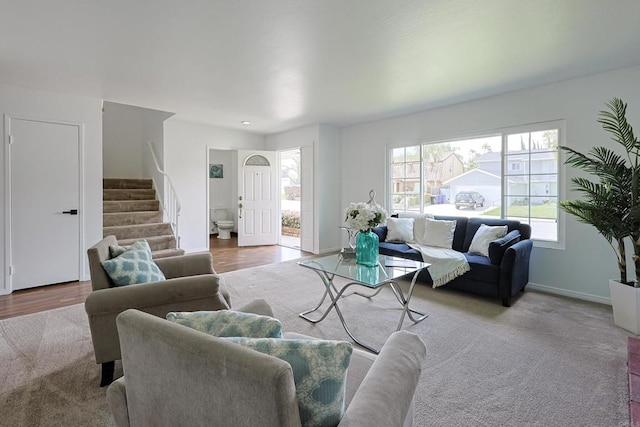 living room with baseboards, stairs, and carpet floors