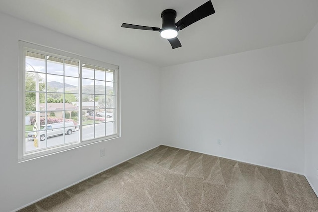 spare room with a ceiling fan and carpet floors