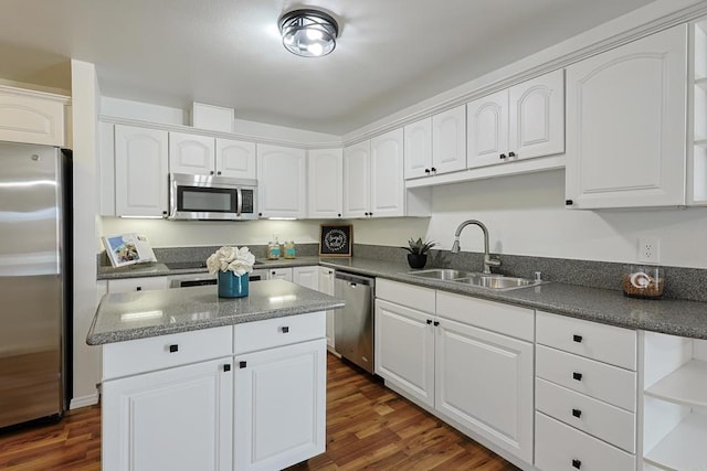 kitchen featuring a center island, dark wood-style floors, a sink, white cabinetry, and appliances with stainless steel finishes