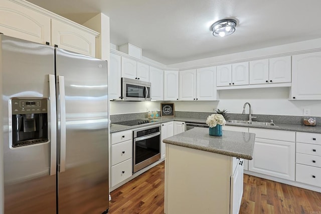 kitchen featuring white cabinetry, a center island, stainless steel appliances, and a sink
