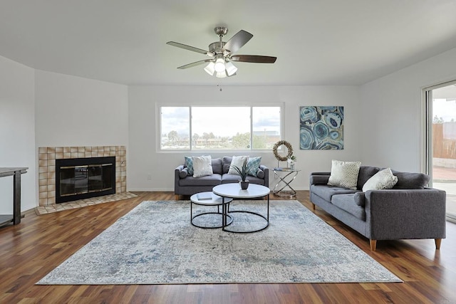 living area featuring a fireplace, wood finished floors, a wealth of natural light, and ceiling fan