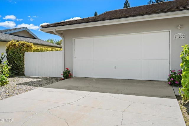 garage with driveway and fence