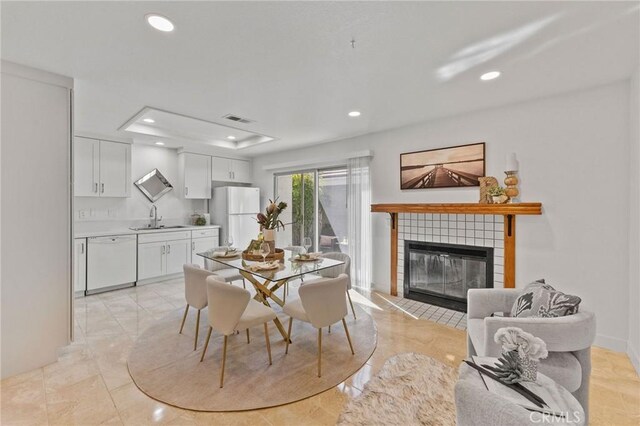 581 Springbrook N, Irvine, CA 92614 - dining space featuring a raised ceiling, a tiled fireplace, visible vents, and recessed lighting