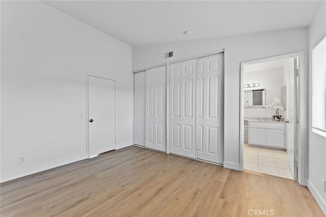 581 Springbrook N, Irvine, CA 92614 - unfurnished bedroom with two closets, ensuite bathroom, light wood-style flooring, visible vents, and lofted ceiling