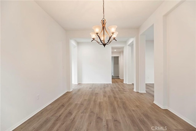 1984 Bronte Rd, San Jacinto, CA 92583 - unfurnished dining area featuring baseboards, light wood-style floors, and a notable chandelier