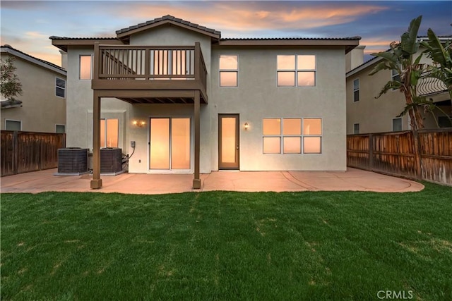 1984 Bronte Rd, San Jacinto, CA 92583 - back of property at dusk with stucco siding, a balcony, a fenced backyard, a patio, and a yard