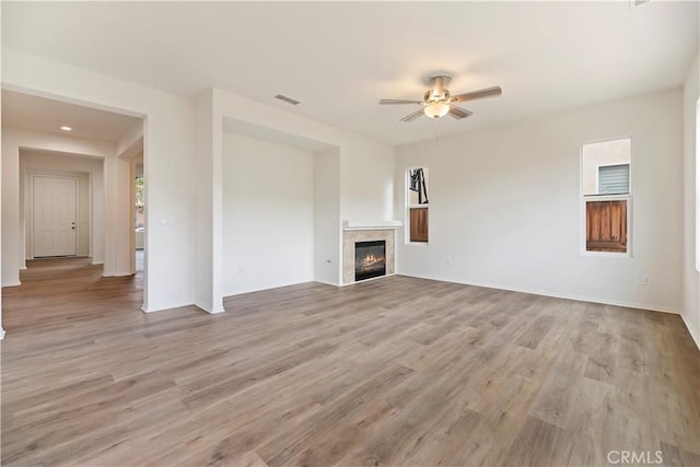 1984 Bronte Rd, San Jacinto, CA 92583 - unfurnished living room featuring visible vents, a glass covered fireplace, a ceiling fan, and light wood finished floors
