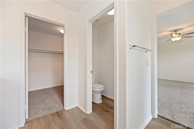1984 Bronte Rd, San Jacinto, CA 92583 - bathroom featuring ceiling fan, toilet, a walk in closet, and wood finished floors