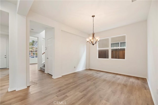 1984 Bronte Rd, San Jacinto, CA 92583 - spare room featuring light wood finished floors, stairs, baseboards, and an inviting chandelier