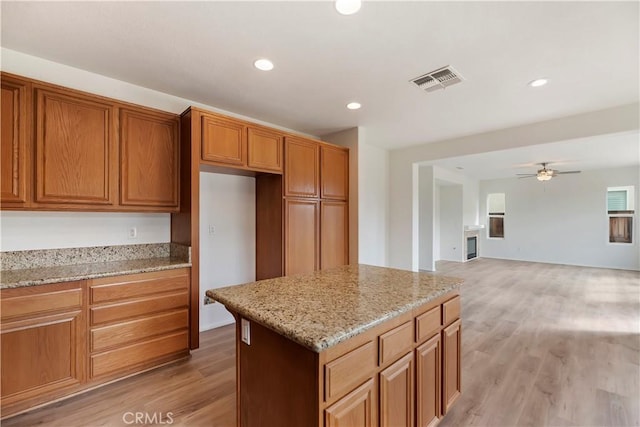 1984 Bronte Rd, San Jacinto, CA 92583 - kitchen featuring recessed lighting, a kitchen island, light stone counters, light wood finished floors, and ceiling fan