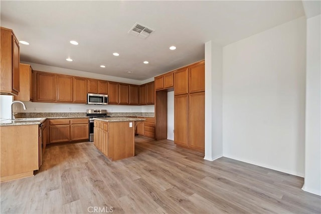 1984 Bronte Rd, San Jacinto, CA 92583 - kitchen featuring light wood-style flooring, visible vents, stainless steel appliances, a kitchen island, and a sink