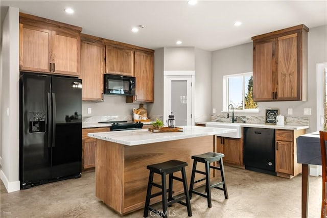 kitchen featuring light countertops, recessed lighting, a sink, and black appliances