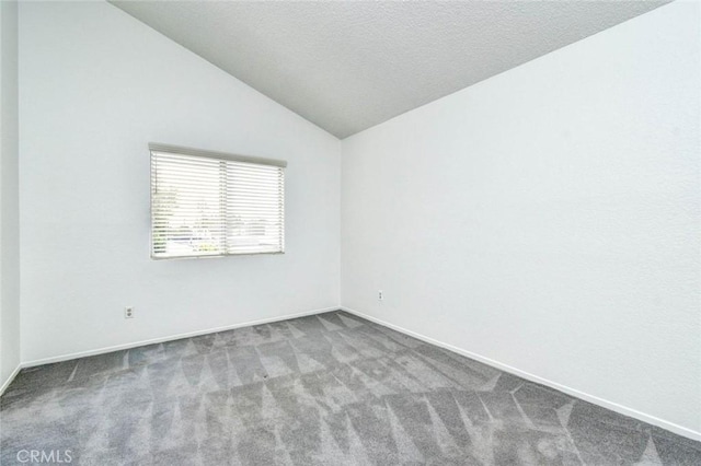 carpeted empty room with baseboards and lofted ceiling