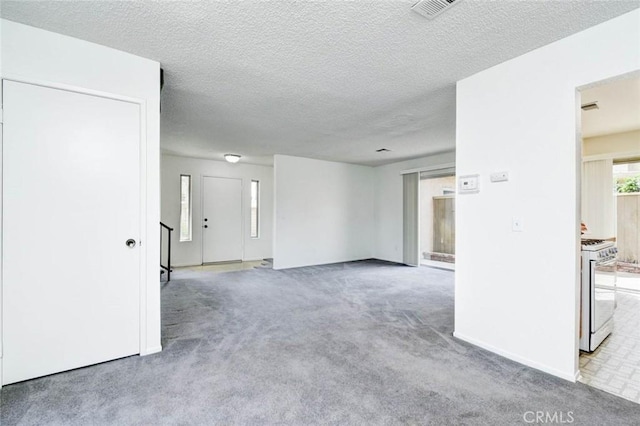 spare room featuring a textured ceiling, visible vents, baseboards, and carpet