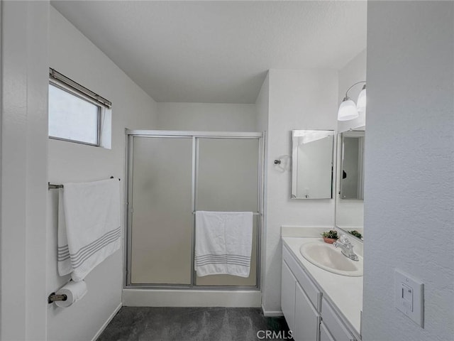 full bathroom featuring vanity, baseboards, and a stall shower