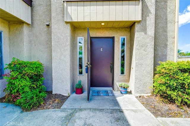 entrance to property featuring stucco siding