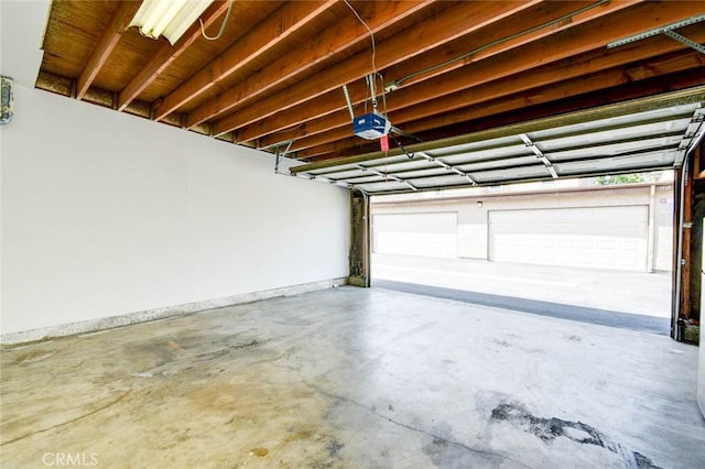 garage featuring a garage door opener and baseboards